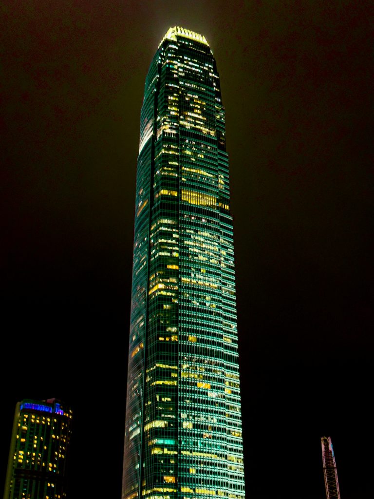 A tall building lit up at night with a green light